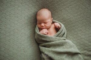 Newborn Photography: a baby boy sleeping on a green textured blanket