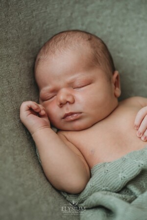Newborn Photography: a baby boy sleeping on a green textured blanket