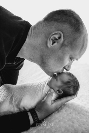 A father kisses his baby girl's head