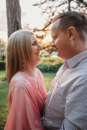 Engagement Photography: a couple stand hugging at sunset