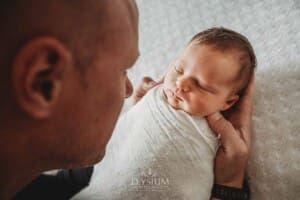 A baby girl lays sleeping in her dad's hands