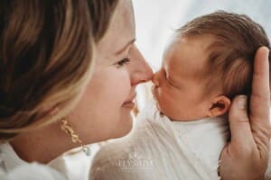 A baby girl lays sleeping in her mum's hands