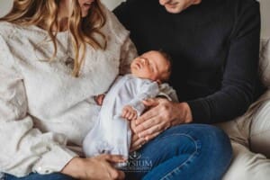 A baby girl lays sleeping in her parents arms