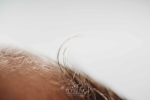 A tuft of hair curls up on a newborn baby