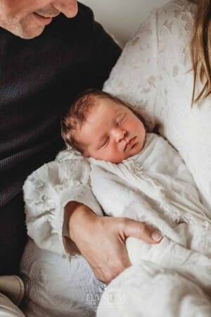 A baby girl lays sleeping in her mother's arm