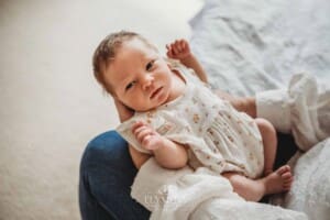 A baby girl lays awake in her mum's hands