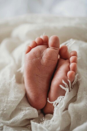 A baby's tiny feet poke out a white wrap