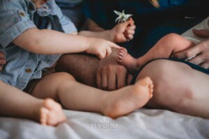Newborn Photography: a little boy touches his baby brother's toes