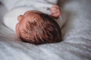 Newborn Photography: a baby boy's soft hair laying on a white blanket