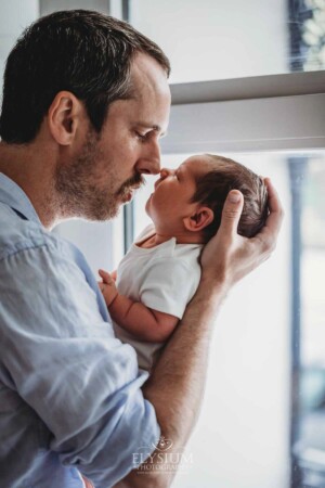 Newborn Photography: a father presses his nose to his baby boys nose