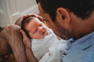 Newborn Photography: a father cradles his baby boy in his hands