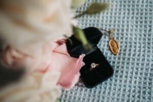 Sydney Wedding - a brides engagement ring sits against her bouquet and Mary pendant
