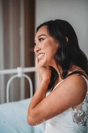 Sydney Wedding - a bride smiles as she puts earrings on