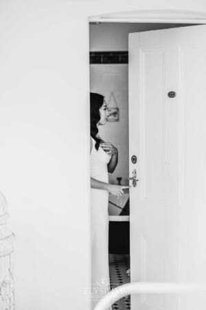 Sydney Wedding - a bride stands in a doorway to check herself in the mirror