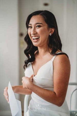Sydney Wedding - a bride laughs as she reads a letter from the groom