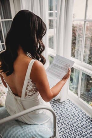 Sydney Wedding - a bride sits on a bed to read a letter from her groom