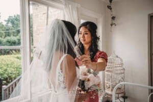 Sydney Wedding - a bridesmaid straightens the brides veil