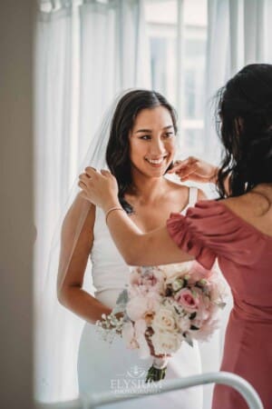 Sydney Wedding - a bridesmaid straightens the brides veil