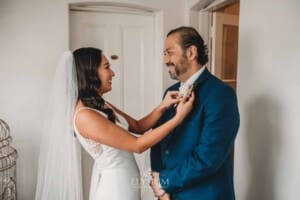 Sydney Wedding - a bride attaches a flower to her father's jacket