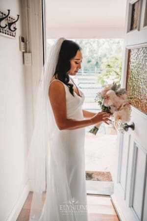Sydney Wedding - a bride fixes her bouquet before walking out the door