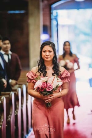 Sydney Wedding - a bridesmaid walks down a church aisle to the ceremony