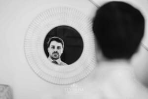 Sydney Wedding - a groom looks at his reflection in a circular mirror