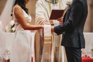Sydney Wedding - a bride and groom hold hands during the priest blessing