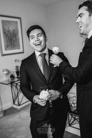 Sydney Wedding - a groomsman laughs as they pin on the jacket flowers