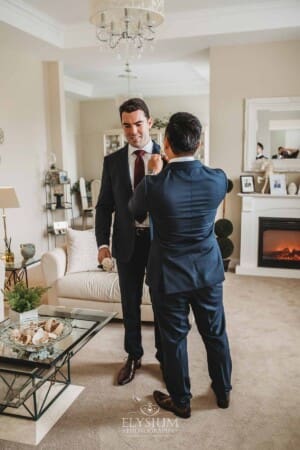 Sydney Wedding - groomsmen pin the flowers onto each others jacket