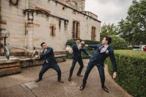 Sydney Wedding - groomsmen pretend to swordfight with the bridal bouquets