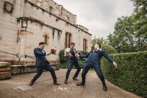 Sydney Wedding - groomsmen pretend to swordfight with the bridal bouquets