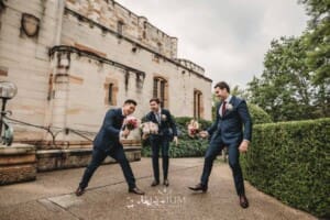 Sydney Wedding - groomsmen pretend to swordfight with the bridal bouquets