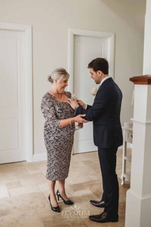 Sydney Wedding - a groom pins the flowers onto his mother's dress