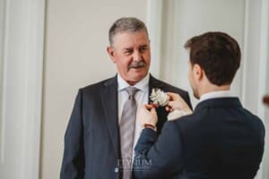 Sydney Wedding - a groom helps pin the flowers onto his father's jacket