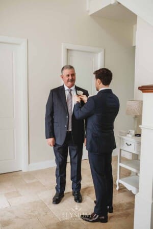 Sydney Wedding - a groom helps pin the flowers onto his father's jacket