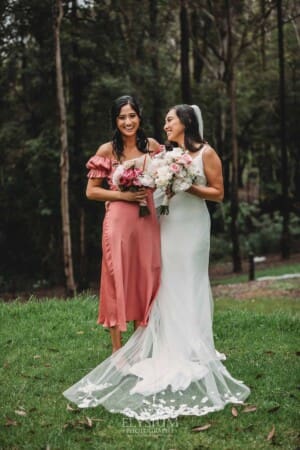 Sydney Wedding - a bride hugs her bridesmaid in the gardens at Springfield House