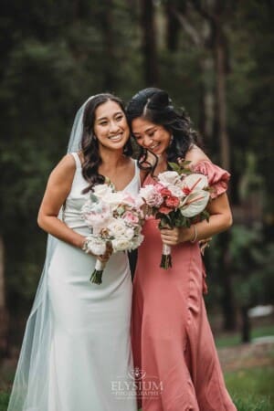 Sydney Wedding - a bride hugs her bridesmaid in the gardens at Springfield House