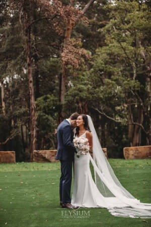 Sydney Wedding - a bride and groom hug in the trees at Springfield House