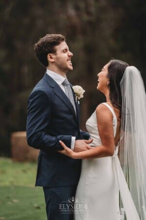 Sydney Wedding - a bride and groom laugh amongst the trees at Springfield House