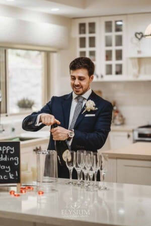 Sydney Wedding - a groom pops the cork off a bottle of champagne