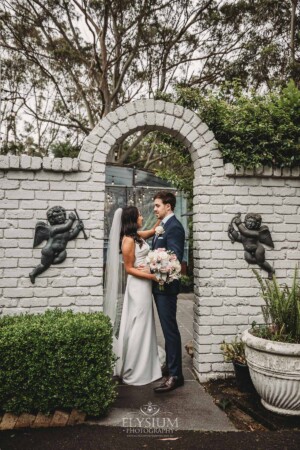 Sydney Wedding - bride and groom kiss beneath an arch at Springfield House