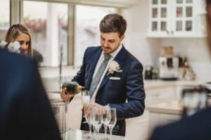Sydney Wedding - the groom pours a glass of champagne to toast