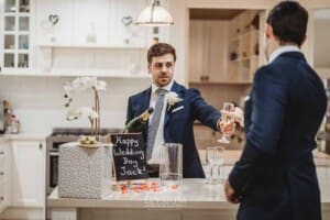 Sydney Wedding - the groom passes his groomsman a glass of champagne