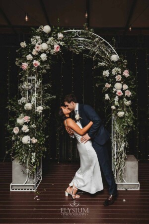 Sydney Wedding - bride and groom kiss beneath an arch at Springfield House