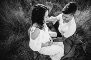 Outdoor Session - a man places his hand on his wife's pregnant belly