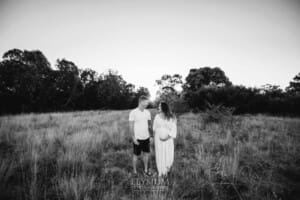 Outdoor Session - a couple stand holding hands in long grass at sunset
