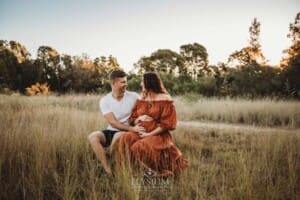 Outdoor Session - a couple sit in long grass at sunset