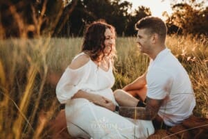 Outdoor Session - a man places his hand on his wife's pregnant belly