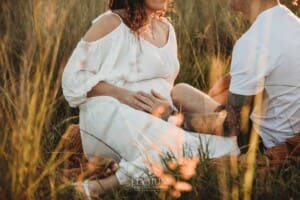 Outdoor Session - a man places his hand on his wife's pregnant belly