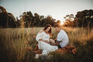 Outdoor Session - a couple sit on a blanket in long grass at sunset